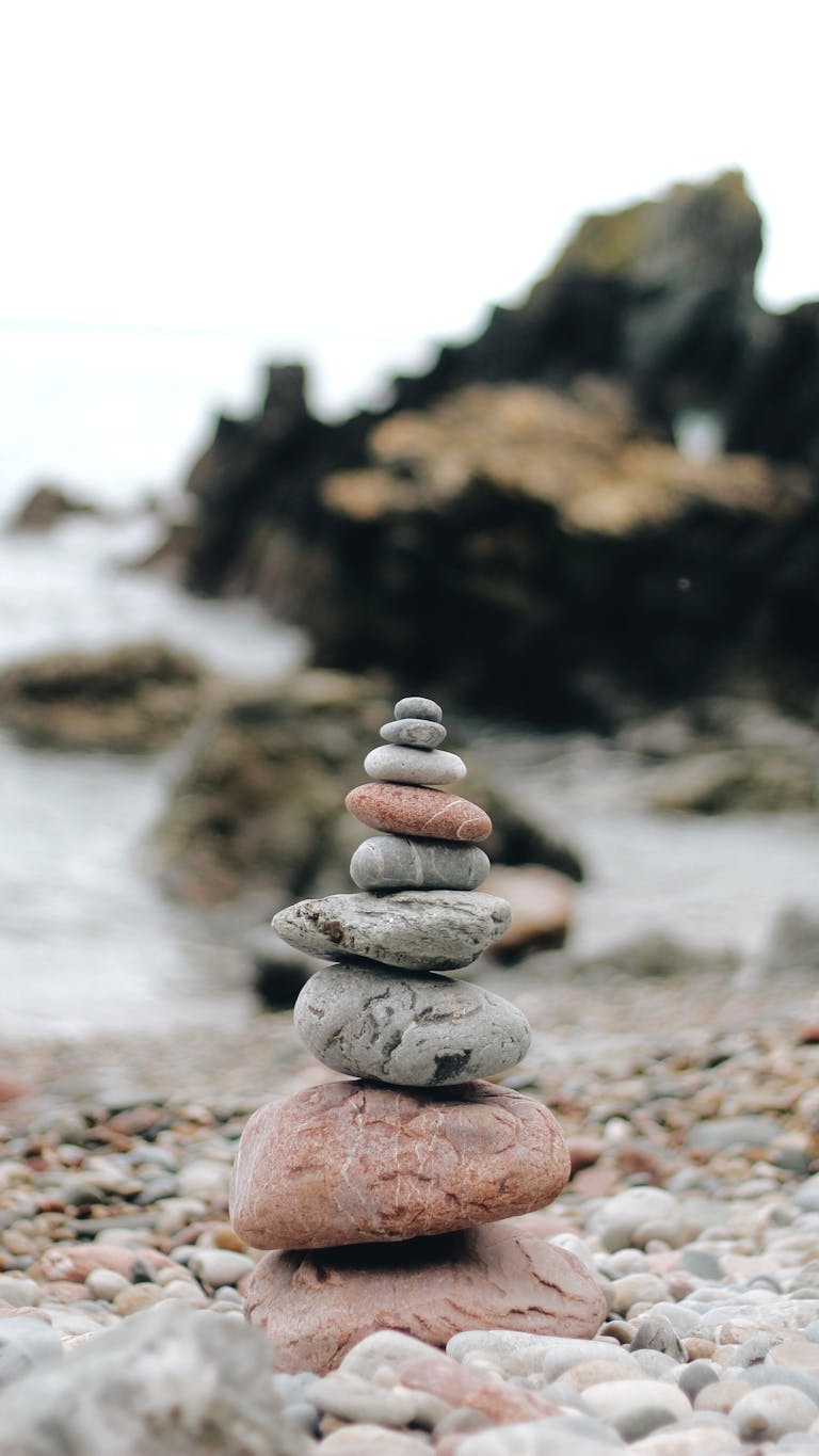 Tranquil stacked stones on a rocky beach, symbolizing balance and calm.
