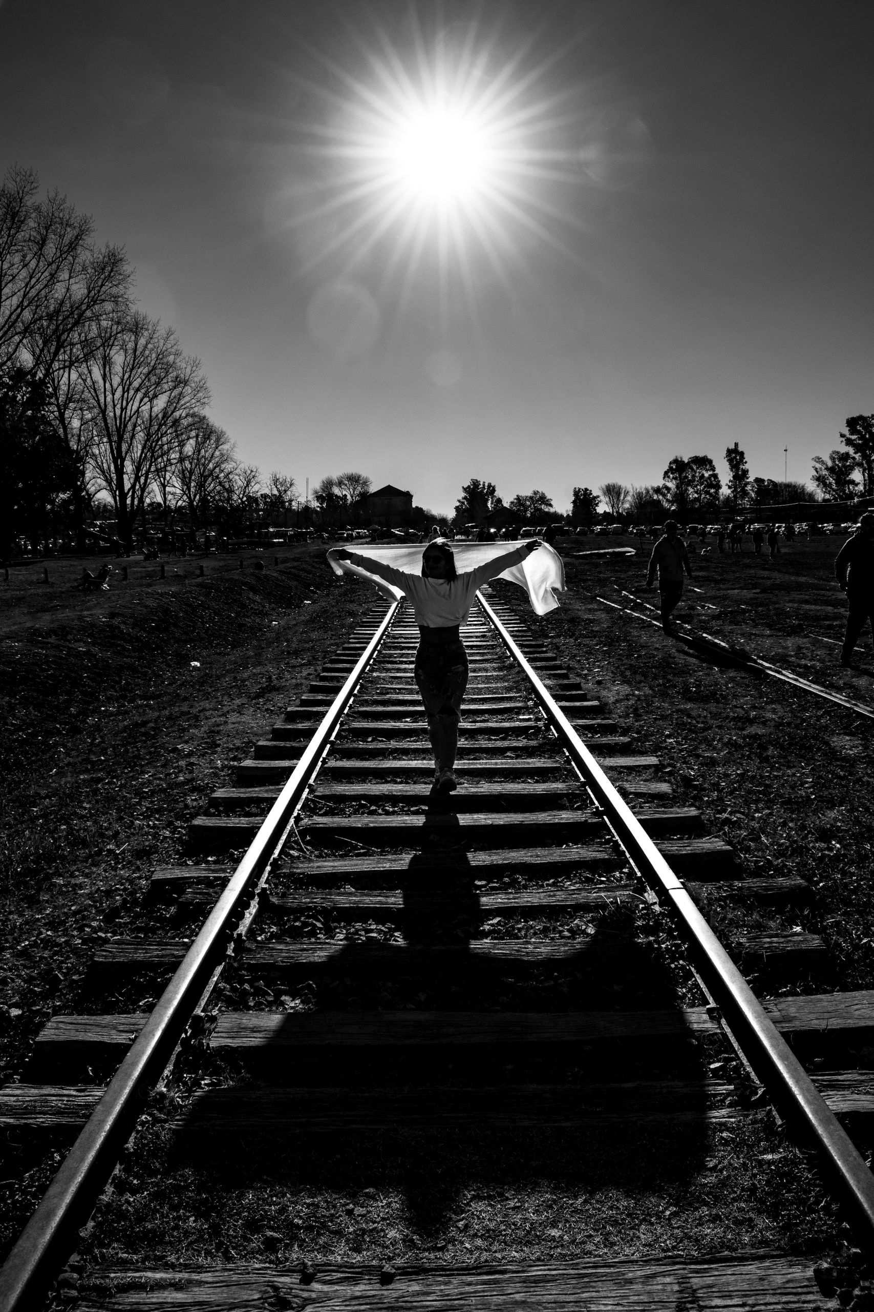 Dramatic black and white photo of a person on railway tracks in Buenos Aires.
